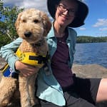 Johanna and her dog on a rock in the boundary waters.