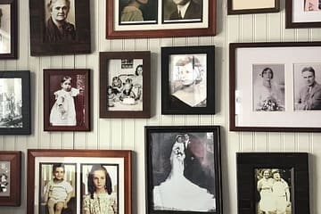 framed ancestor photos hanging on a wall