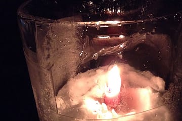 Candle glowing inside ice.